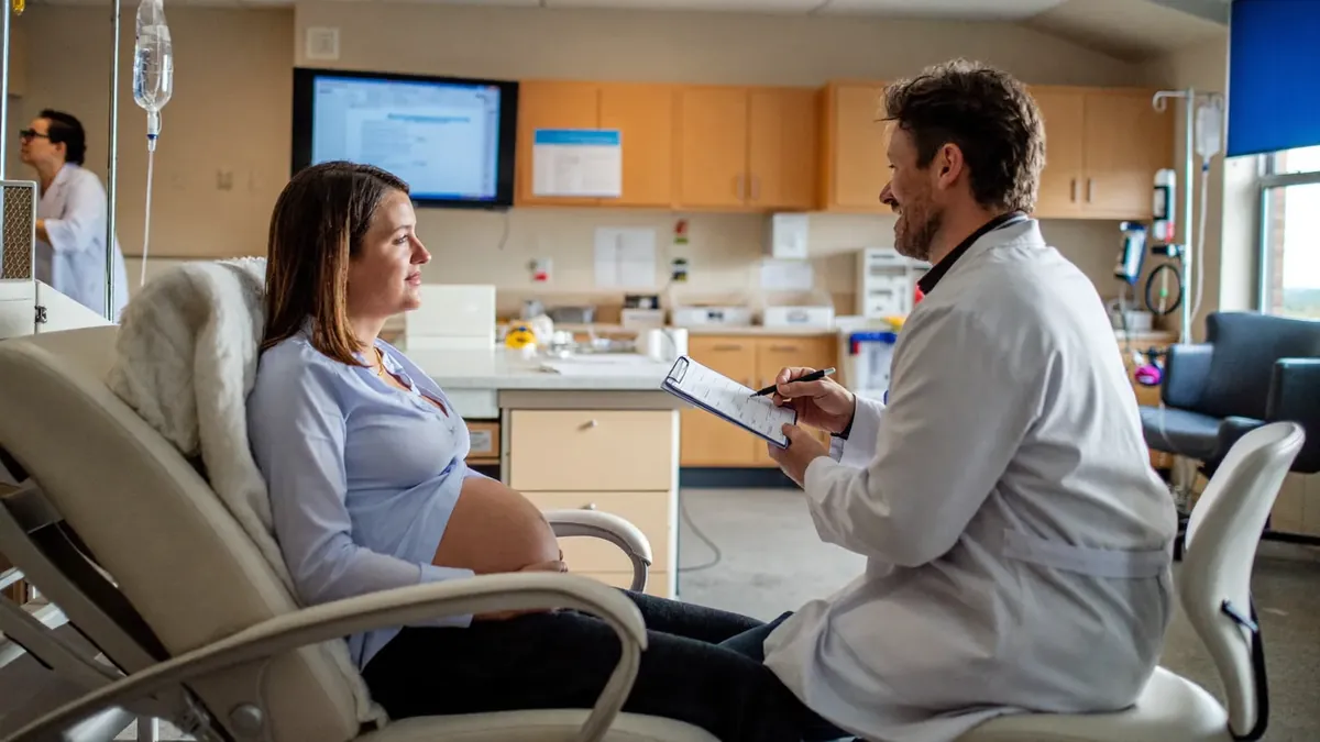 An expecting couple at a prenatal visit with a doctor in a bright Colorado clinic